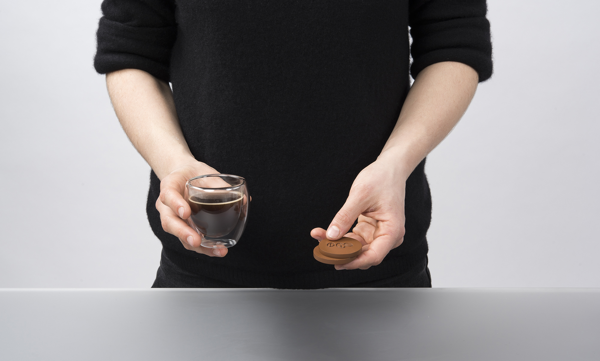 Hand holding an espresso cup